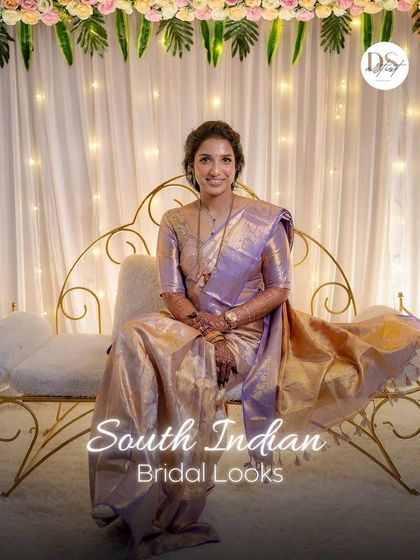 Seated like royalty, this South Indian bride exudes grace. Her makeup is soft and luminous, with a gentle lavender sheen on the saree that is subtly reflected in her makeup tones.
