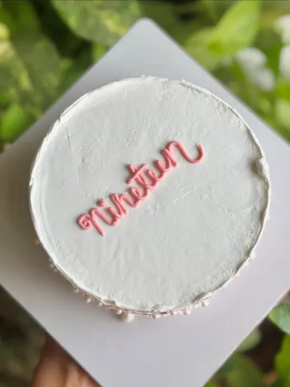 "Nineteen." A simple and chic minimalist cake with a textured top and a delicate pearl border, perfect for an elegant birthday.