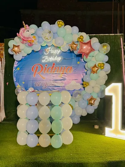 A full view of the outdoor unicorn birthday setup, complete with unicorn balloon pillars.
