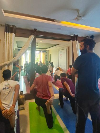 Our instructor provides guidance and support during a class, ensuring students maintain proper alignment in a lunge pose. We are committed to hands-on, personalized instruction.