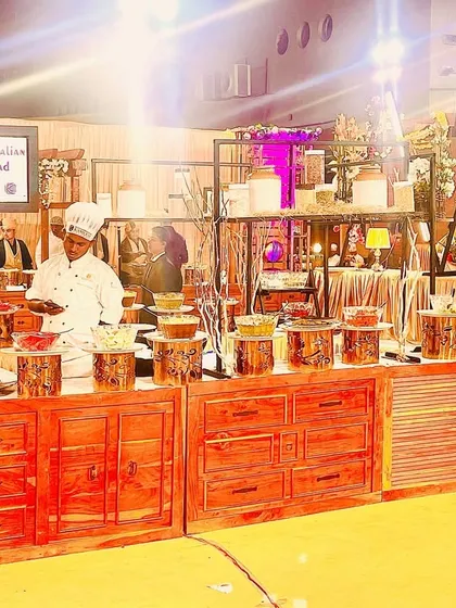 This rustic setup with warm wooden counters and soft lamp lighting creates a cozy and welcoming feel. It's perfect for corporate offsites or relaxed team celebrations.