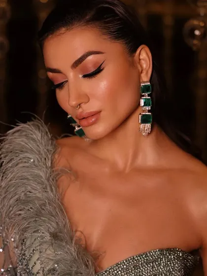 Another close-up of the edgy, glamorous look. The styling focuses on the winged eyeliner and the stunning statement earrings.
