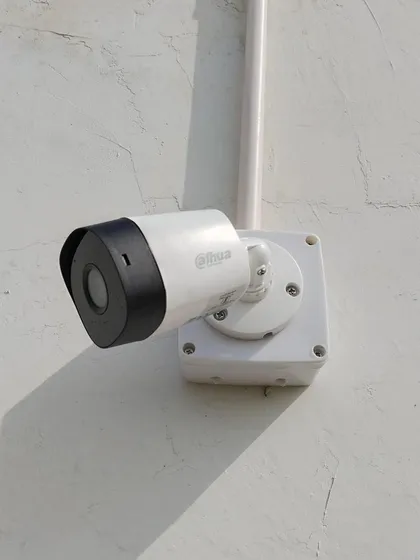 Another example of a clean outdoor installation of a Dahua bullet camera against a white wall.
