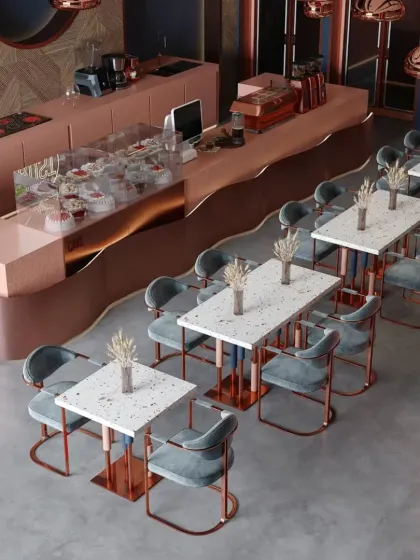 An overhead view of a cafe with a striking rose-gold and teal color scheme. The layout is clean and geometric, with terrazzo-style tables.