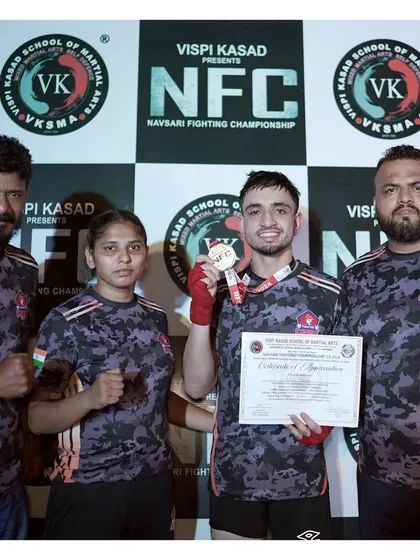 Our coaching team with one of our senior fighters after his win. The guidance from experienced coaches is key to success in the cage.