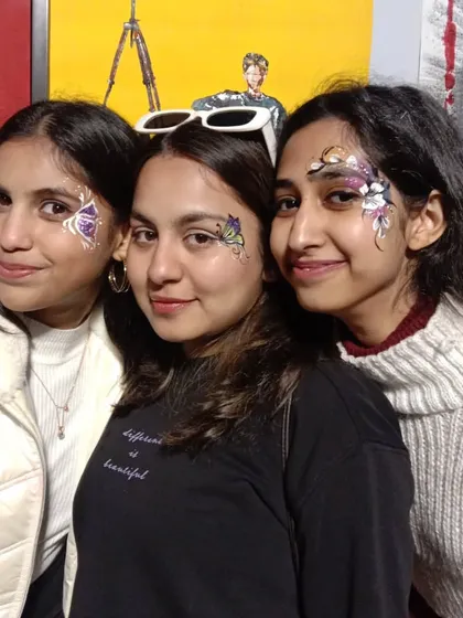 There's nothing better than sharing the fun with friends. Here's a group showing off their coordinated butterfly face art at a college fest. Getting painted together is a great way to make memories at any event.