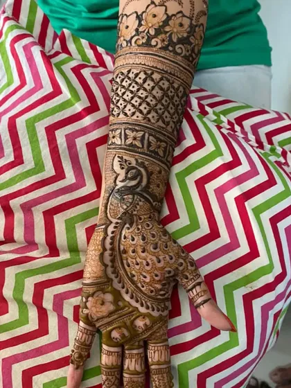 An elegant full-arm bridal design featuring a majestic peacock. The combination of delicate feather details and geometric patterns creates a truly royal look.