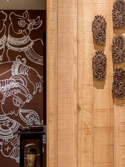 The mural integrates with other traditional elements in the boutique, like carved wooden blocks, creating a cohesive and culturally rich environment.