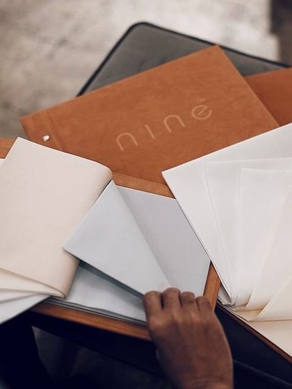 The hands-on experience of choosing a fabric is something we encourage. Here, a client is exploring different textures and weights for a custom garment gift.