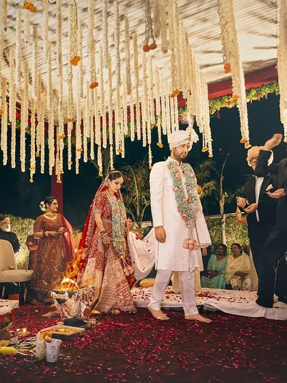 The bride and groom take their first steps as husband and wife during the pheras, surrounded by their loved ones.