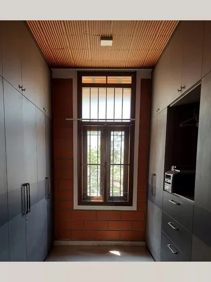 A walk-in closet with a terracotta tile ceiling and an exposed brick accent wall, showing that even storage spaces can be designed with natural materials.