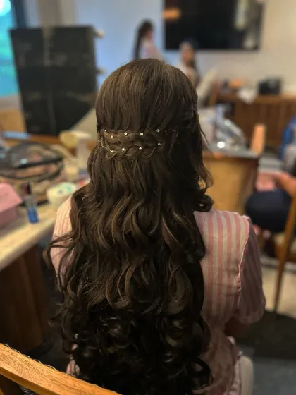 A simple half-up style with a waterfall braid, adorned with delicate pearl pins for a touch of elegance.