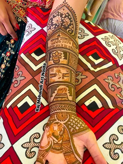 A close-up of a bridal forearm design with story panels. This piece includes a Ganesh motif for good luck, a kalash, and a depiction of the sacred fire ceremony (havan).