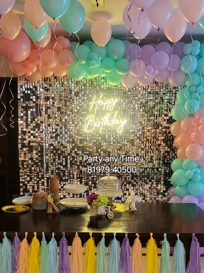 A beautiful pastel balloon decoration over a dining table with a shimmer wall backdrop.
