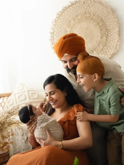 A candid moment of joy as a family welcomes their newest member. Capturing the interaction between parents, a new baby, and an older sibling is always special.