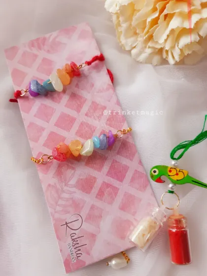 I love the vibrant energy of this crystal chip Rakhi set. The colorful stones are set on a simple red thread for bhai and a gold chain bracelet for bhabhi, making it a fun and modern choice.