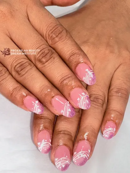 A soft and pretty design with a pink base, a touch of purple glitter at the tips, and delicate white swirls. This is a lovely, understated look for shorter almond nails.