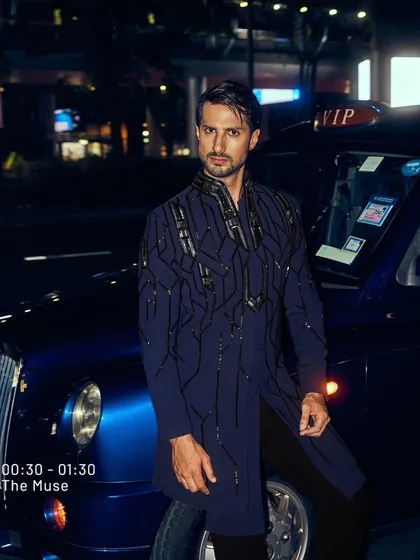 I designed this piece for the man who owns the night. The deep blue fabric is structured with architectural, hand-embroidered patterns, creating a look of unapologetic power. It is a modern statement for a cocktail event or a grand reception.