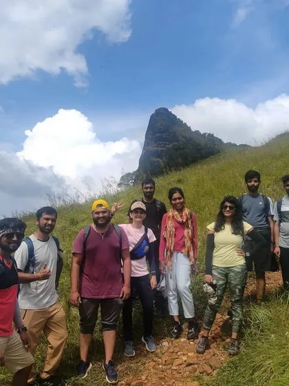 Another group photo on the trail, with the Kurinjal peak visible in the background.