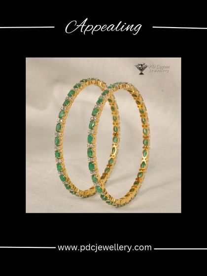 A stunning pair of emerald and diamond bangles. Crafted in 18kt hallmarked gold, these bangles alternate between vibrant green emeralds and sparkling diamonds for a colorful, luxurious look.