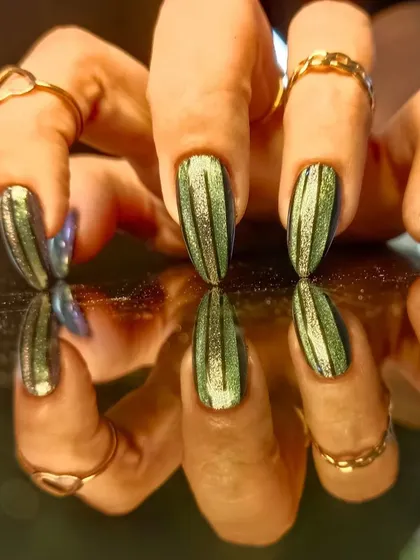 A different angle of the striped green cat-eye nails, showing off the interesting pattern.