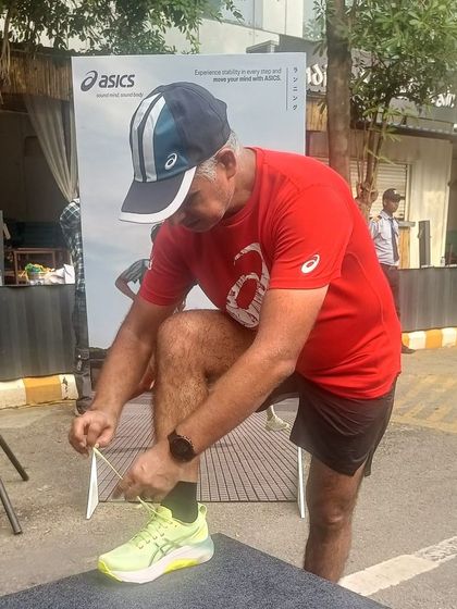 Tying my laces before a run. As a coach, I lead by example, emphasizing preparation and the right equipment.