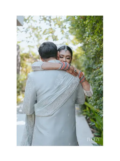 A beautiful, candid moment of the bride hugging her groom from behind, her eyes filled with love and happiness. These are the quiet, in-between moments we cherish.
