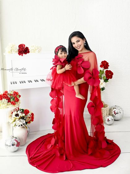 A stunning portrait of a mother and daughter in vibrant red. Their matching outfits and confident poses create a powerful and beautiful image of their special bond.