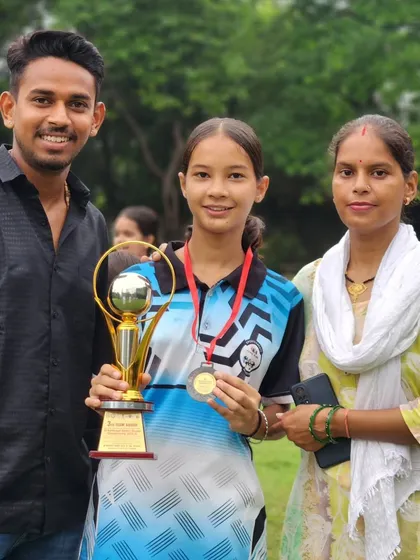 This young girl and her family are all smiles after she won a trophy and medal at the district championship.