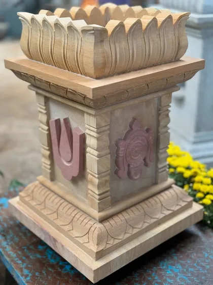 Our Shanku Chakra Nama Brindavan, or ತುಳಸಿ ಕಟ್ಟೆ (Tulasi Katte), is a sacred planter for the holy basil plant. This piece, carved from sandstone with contrasting pink stone details, represents divine harmony and is a beautiful focal point for daily prayers.