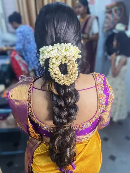 A modern take on a floral braid. This style uses a mix of braiding techniques and is adorned with a gajra for a fresh, contemporary look.