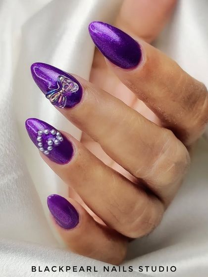 An exquisite set of purple nails featuring delicate pearl hearts and charming 3D bow embellishments. Each detail is carefully crafted to create a look of pure sophistication and charm.