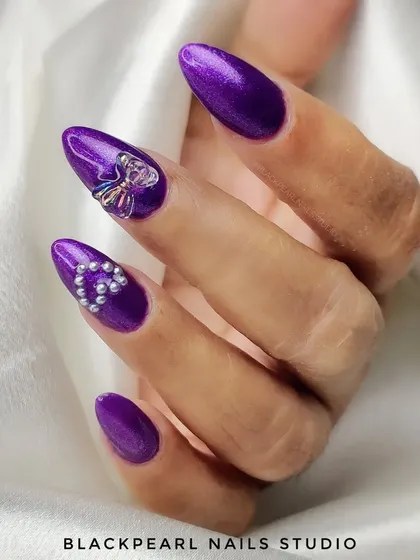 An exquisite set of purple nails featuring delicate pearl hearts and charming 3D bow embellishments. Each detail is carefully crafted to create a look of pure sophistication and charm.
