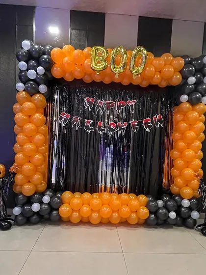 I love creating fun, themed parties, and this Halloween setup is a great example. I built a complete photo booth with a black and orange balloon frame, a shiny tinsel curtain, "BOO" foil balloons, and spooky pumpkin figures. It's perfect for office parties or home celebrations.