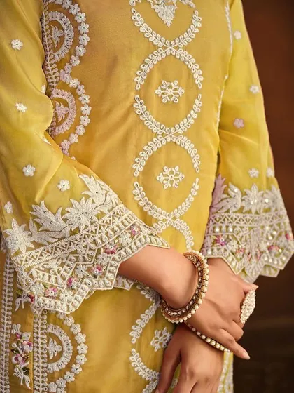 Shine bright in this yellow organza Anarkali suit. The heavy white thread embroidery and sequin work make it a perfect outfit for a Haldi ceremony or festive celebration.