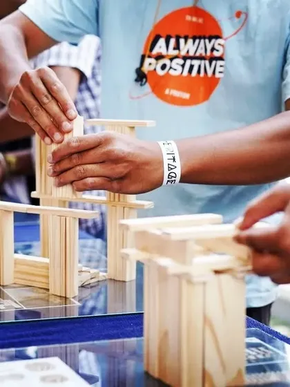 Focus is a skill you can practice. In this shot, a participant is completely absorbed in the task of placing a block. Our hands-on activities serve as a form of digital detox, helping team members reconnect with the present moment and improve their concentration.