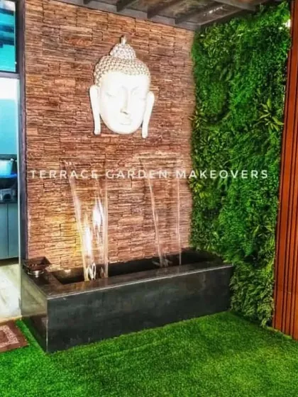 I love creating spaces that bring a sense of peace. This corner combines an artificial green wall with a stone-textured accent wall, a calming water feature, and a Buddha head sculpture to create a personal spot for relaxation.
