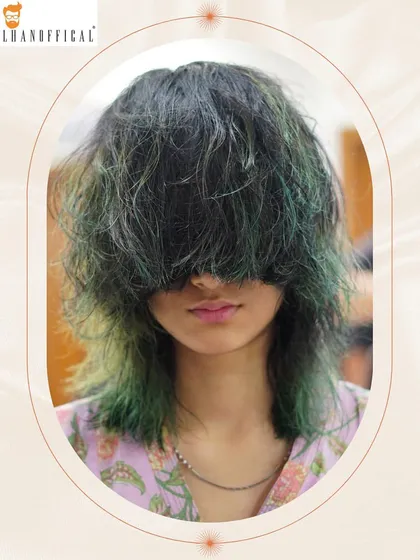 A playful shot of the green-tipped shag cut, with hair covering the face to emphasize the unique color and messy texture.