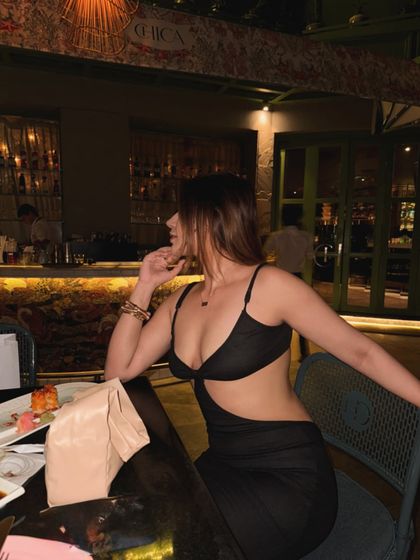 A black cutout dress styled for dinner at a chic restaurant, showing a hint of skin.