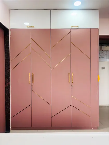 A stunning pink wardrobe with a geometric gold inlay pattern. The gold handles complete the luxurious and chic look.