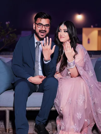 A happy couple showing off their rings. Her makeup is soft and pretty, with a focus on a flawless base and defined eyes that sparkle.