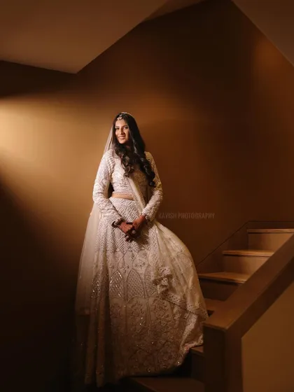 A full-length color portrait on the staircase, showing the bride in her beautiful attire.