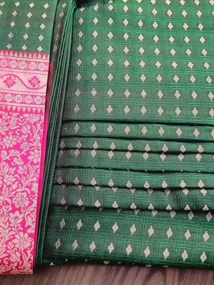 A client's green and pink silk saree, pre-pleated and ready for her event.