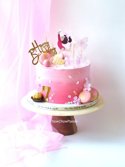 A full view of the gymnastics-themed cake, showing all the pretty pink details.