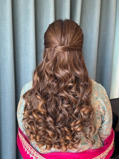 A clean and polished half-up style with a simple twist holding the hair back. The curls are well-defined with beautiful highlights.