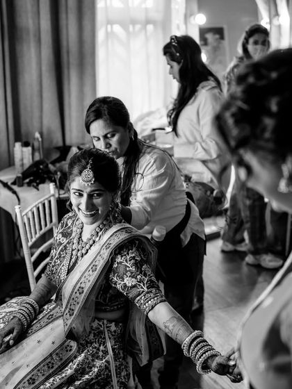 A candid, black and white shot of Sneha during her getting-ready process. It captures the joy and excitement of the wedding day.