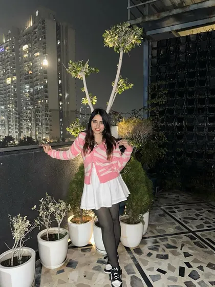 A cute and preppy look with a pink and white cardigan and a white skirt. This is a great outfit for a casual evening outing.