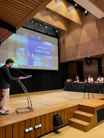 A participant presents during the Read-Aloud competition held in our auditorium. These events give students a platform to showcase their language skills.