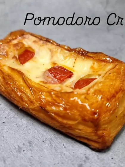This is my Pomodoro Crust, a savory pastry. It's a flaky, buttery crust filled with a creamy cheese mixture and topped with pieces of fresh tomato, baked until golden.