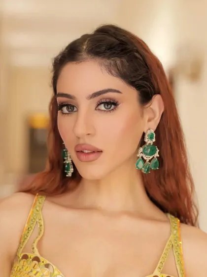 A close-up "hello sunshine" look. The bright yellow outfit by Liz Paul is paired with statement emerald earrings, creating a fresh and vibrant style for a Haldi or Mehendi function.